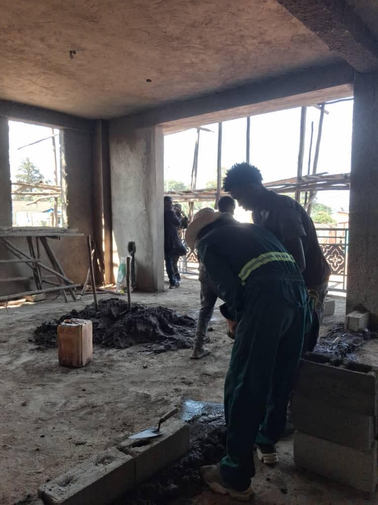 Builders working with concrete blocks inside the hospital